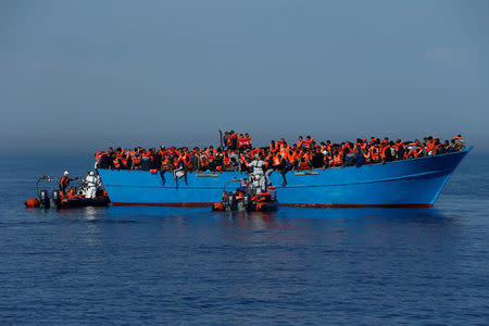 FILE PHOTO: Migrants on a wooden boat are rescued by the Malta-based NGO Migrant Offshore Aid Station (MOAS) in the central Mediterranean in international waters off the coast of Sabratha in Libya, April 15, 2017. REUTERS/Darrin Zammit Lupi/File Photo