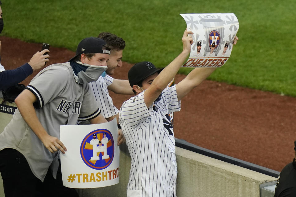 New York Yankees fans hold signs before the start of a baseball game between the New York Yankees and the Houston Astros Tuesday, May 4, 2021, in New York. (AP Photo/Frank Franklin II)