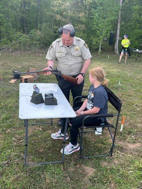 A member of Panola County Sheriff’s Office teaches a child about shotgun safety. Photo courtesy of Panola County Sheriff’s Office.