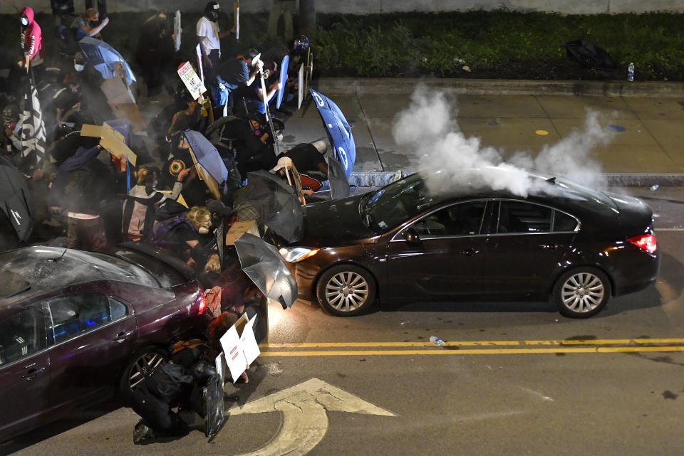 Demonstrators clash with police officers a block from the Public Safety Building in Rochester, N.Y., Friday, Sept. 4, 2020, after a rally and march protesting the death of Daniel Prude. Prude apparently stopped breathing as police in Rochester were restraining him in March 2020 and died when he was taken off life support a week later. (AP Photo/Adrian Kraus)