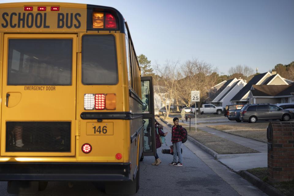 Liam Lazo boards a diesel school bus near his home, Tuesday, Feb. 6, 2024, in Virginia Beach, Va. Diesel exhaust from school buses affects one-third of U.S. students, their parents and educators each day. (AP Photo/Tom Brenner)