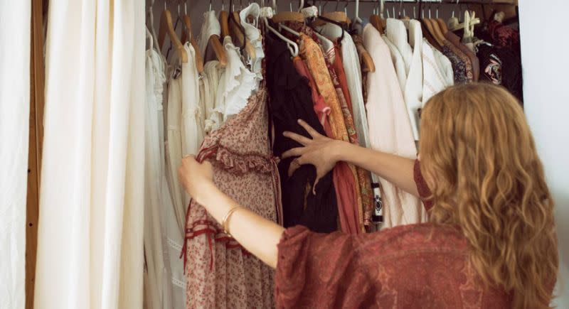 Eine Frau sieht ihren Kleiderschrank durch [Foto: Getty]