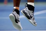 The shoes of Serena Williams of the U.S. are seen as she serves to Kiki Bertens of the Netherlands during their match at the U.S. Open Championships tennis tournament in New York, September 2, 2015. REUTERS/Mike Segar