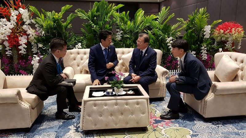 South Korean President Moon Jae-in talks with Japanese Prime Minister Shinzo Abe during their bilateral meeting in Bangkok