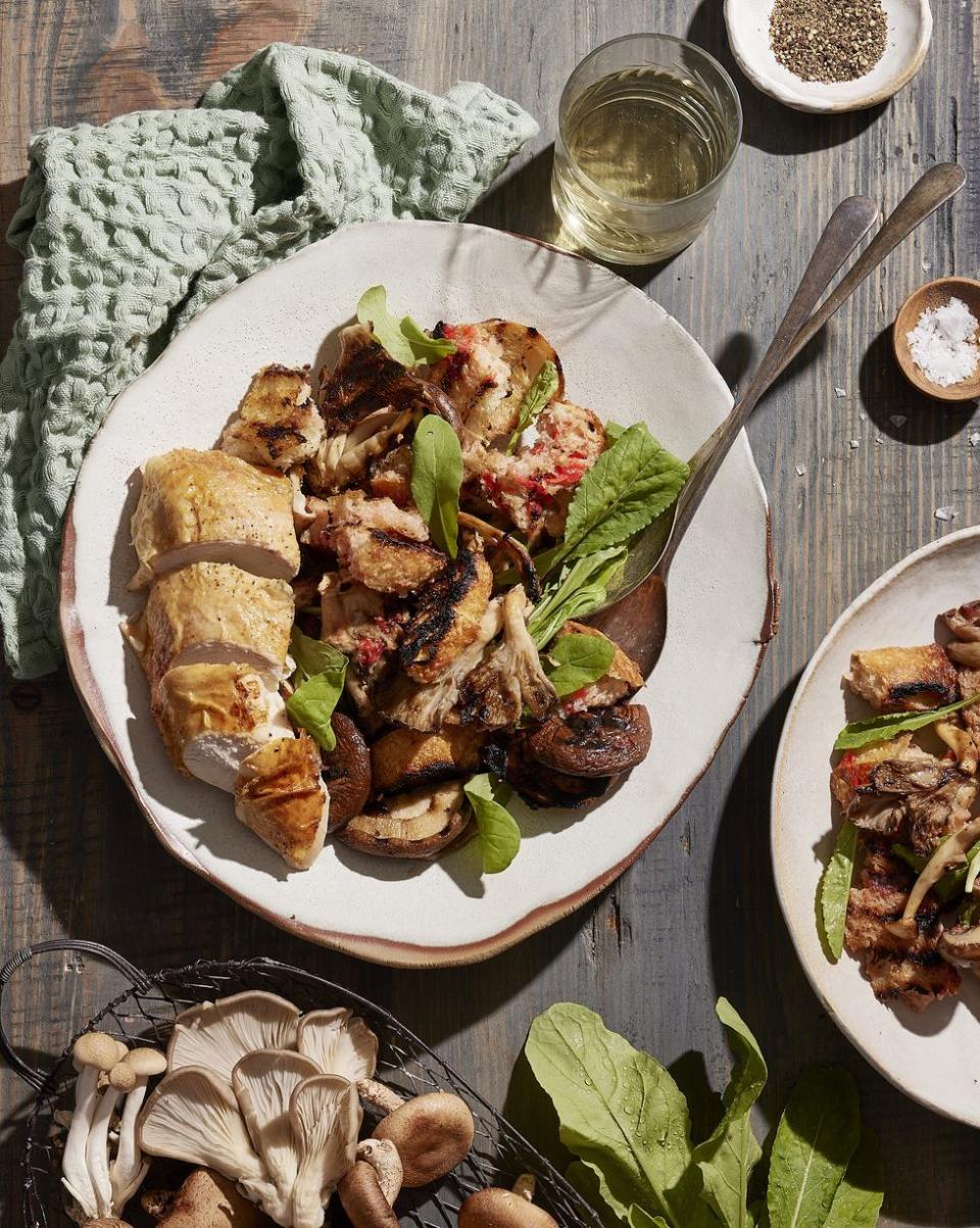 grilled mushroom panzanella with tomato vinaigrette on a white plate with silverware