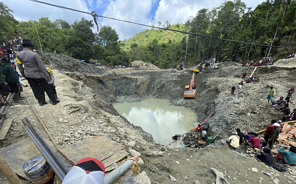 Rescuer workers pump water out of a collapsed gold mine as they search for victims in Parigi Moutong, Central Sulawesi, Indonesia, Thursday, Feb. 25, 2021. The illegal gold mine in Central Indonesia collapsed on miners working inside, leaving a number of people killed, officials said Thursday. (AP Photo/Abdee Mari)