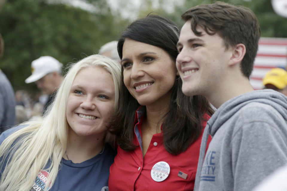 Democratic presidential candidate U.S. Rep. Tulsi Gabbard, D-Hawaii, center, poses for a photo with supporters at the Polk County Democrats Steak Fry, in Des Moines, Iowa, Saturday, Sept. 21, 2019. (AP Photo/Nati Harnik)