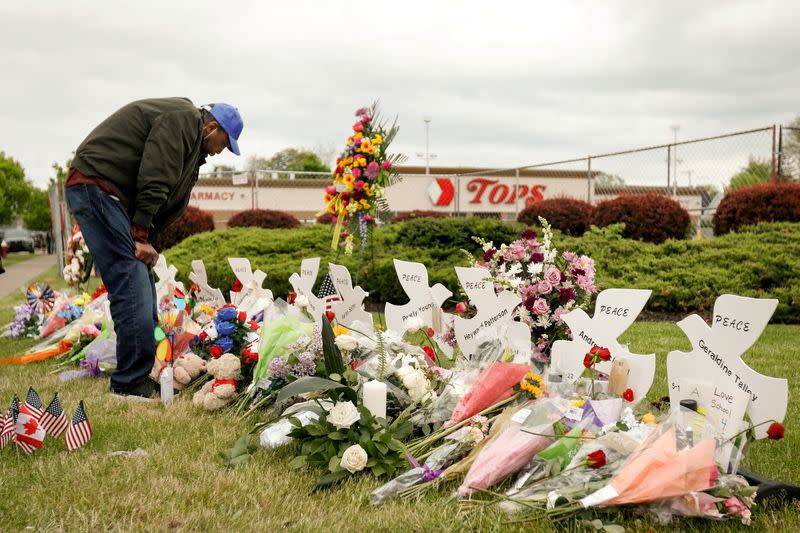 FILE PHOTO: Man mourns at a memorial at the scene of a weekend shooting at a Tops supermarket in Buffalo, New York