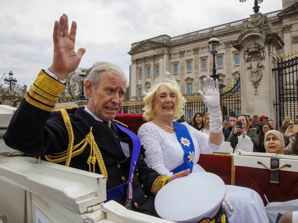 Lookalikes of King Charles III and Camilla, the Queen Consort, pass Buckingham Palace in April (Mark Thomas/Shutterstock)