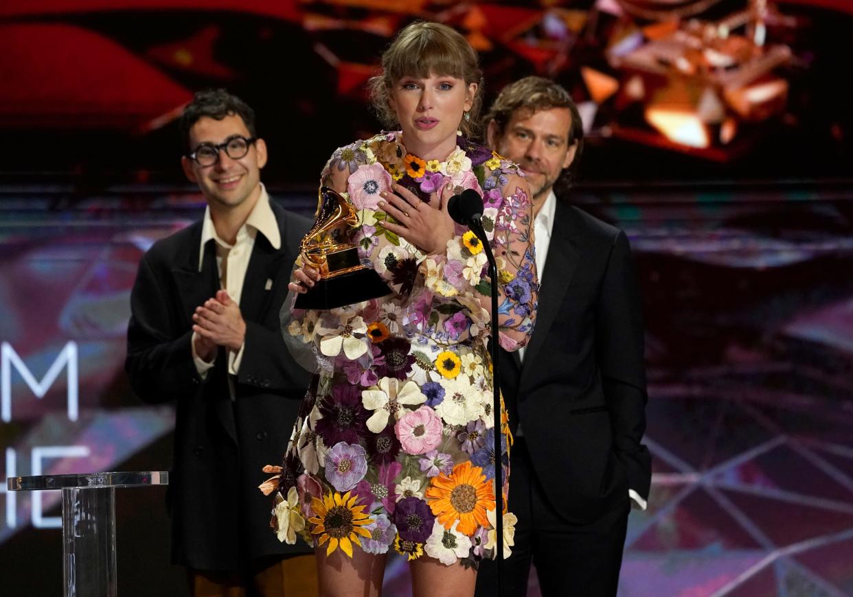 Taylor Swift accepts the award for album of the year for "Folklore"at the 63rd annual Grammy Awards at the Los Angeles Convention Center on Sunday, March 14, 2021. In background Jack Antonoff, left, and Aaron Dessner. (AP Photo/Chris Pizzello) ORG XMIT: CADC889