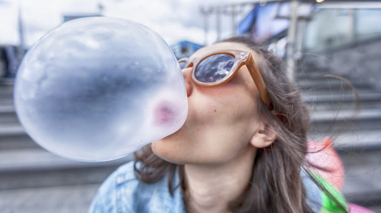 woman blowing bubble with gum