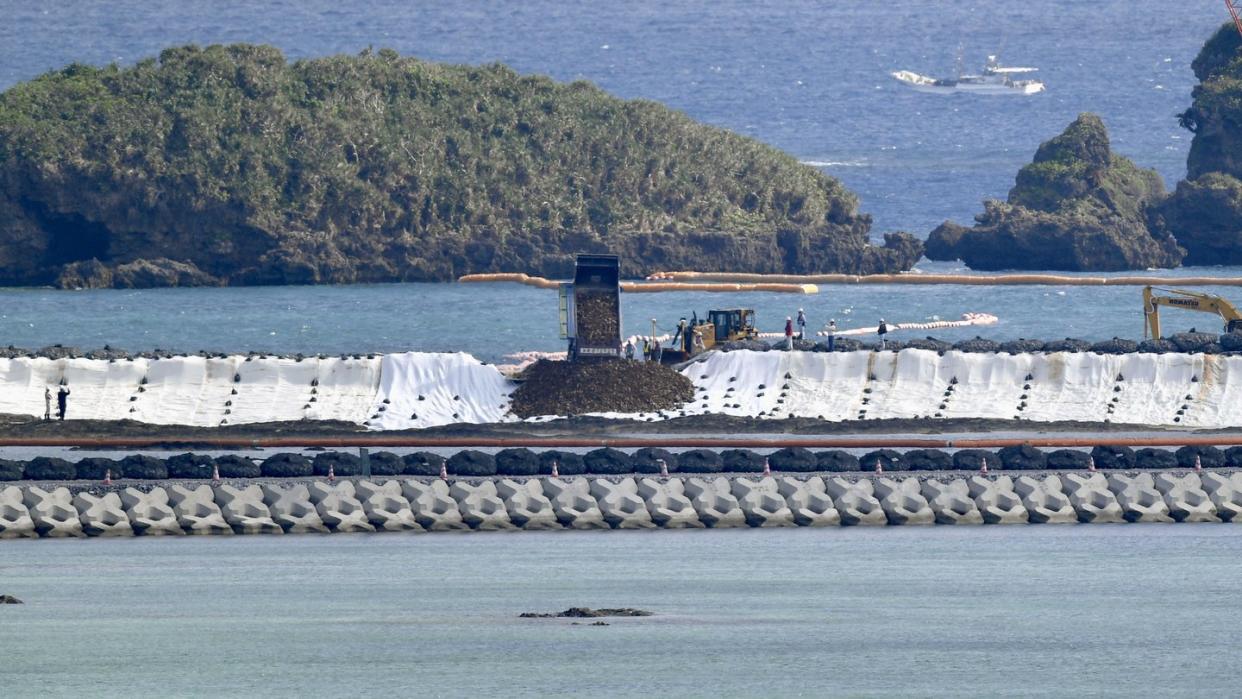 Ein LKW kippt Erdmassen zur Landgewinnung ins Meer. Foto: kyodo