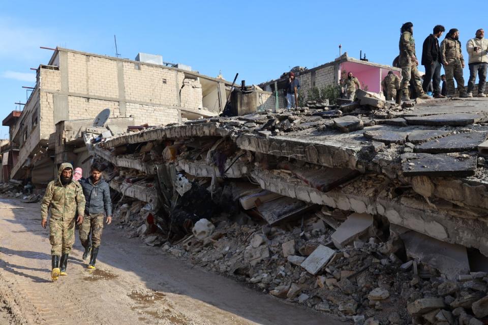 Syrian rescuers gather above the rubble of a collapsed building, on February 7, 2023, in the town of Jandaris, in the rebel-held part of Aleppo province, as a search operation continues following a deadly earthquake (AFP via Getty Images)