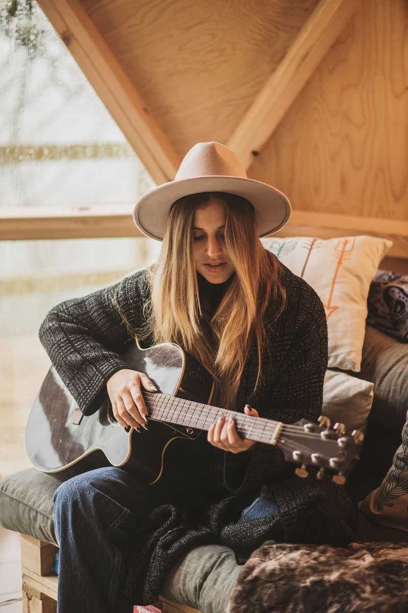 A woman playing an acoustic guitar