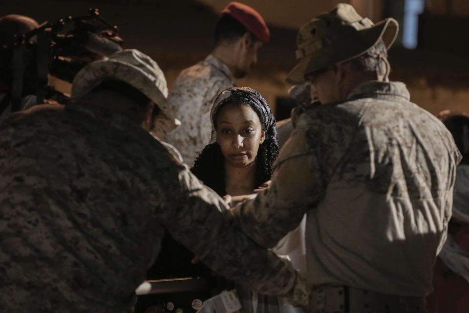 A Canadian evacuee Sagda Ahmed, 20, is checked by Saudi commandos at Port Sudan before boarding a Saudi military ship to Jeddah port, late Tuesday, May 2, 2023. Exhausted Sudanese and foreigners joined growing crowds at Sudan's main seaport Tuesday, waiting to be evacuated from the chaos-stricken nation. After more than two weeks of fighting, areas of the capital of Khartoum appear increasingly abandoned. (AP Photo/Amr Nabil)