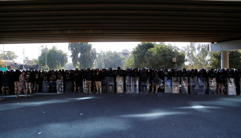 Iraqi riot police stand by as supporters of Iraqi Shiite parties disputing the vote results gather before the final verdict ratifying election results is issued by Iraq's Supreme Court, in Baghdad