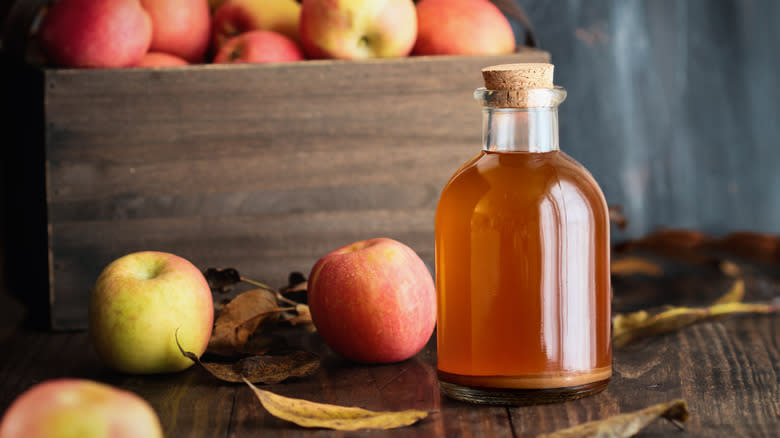 Apple cider vinegar and crate of apples