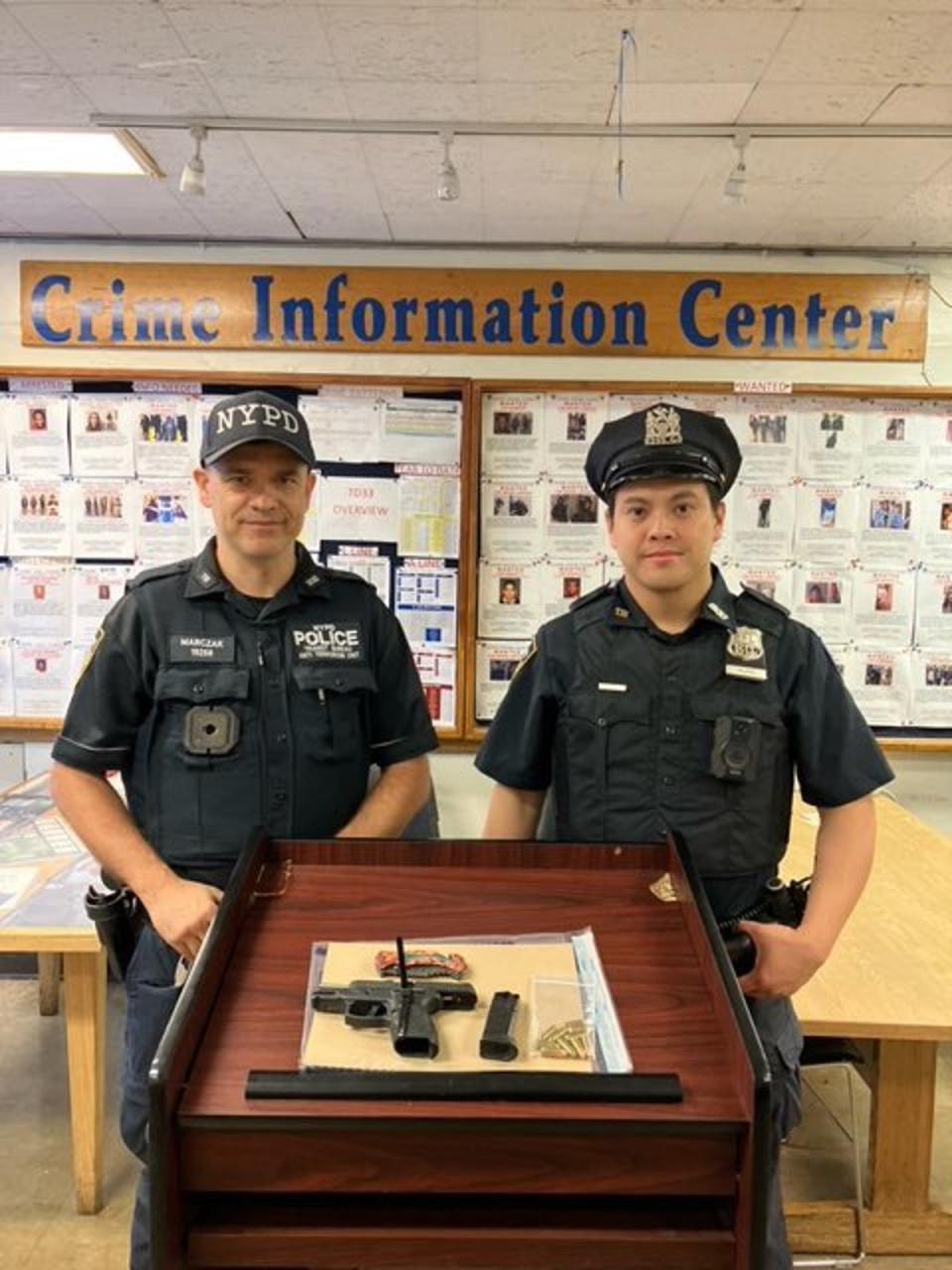 Officers pose with the gun that they seized from the sleeping man on the subway they arrested on Sunday (NYPD  Chief of Transit)