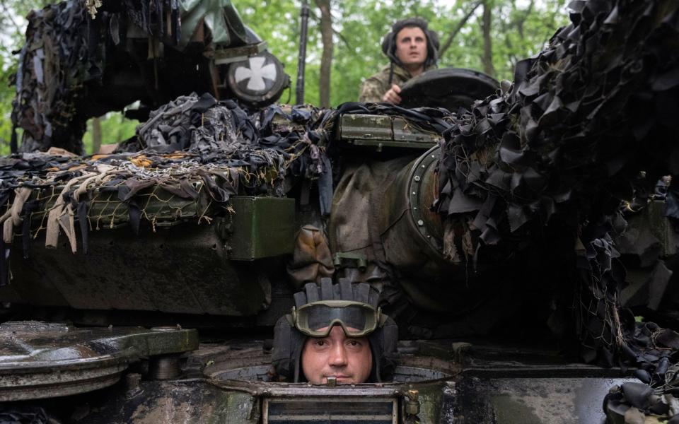 Ukrainian tankers look on as they ride along the road towards their positions near Bakhmut - Efrem Lukatsky/AP