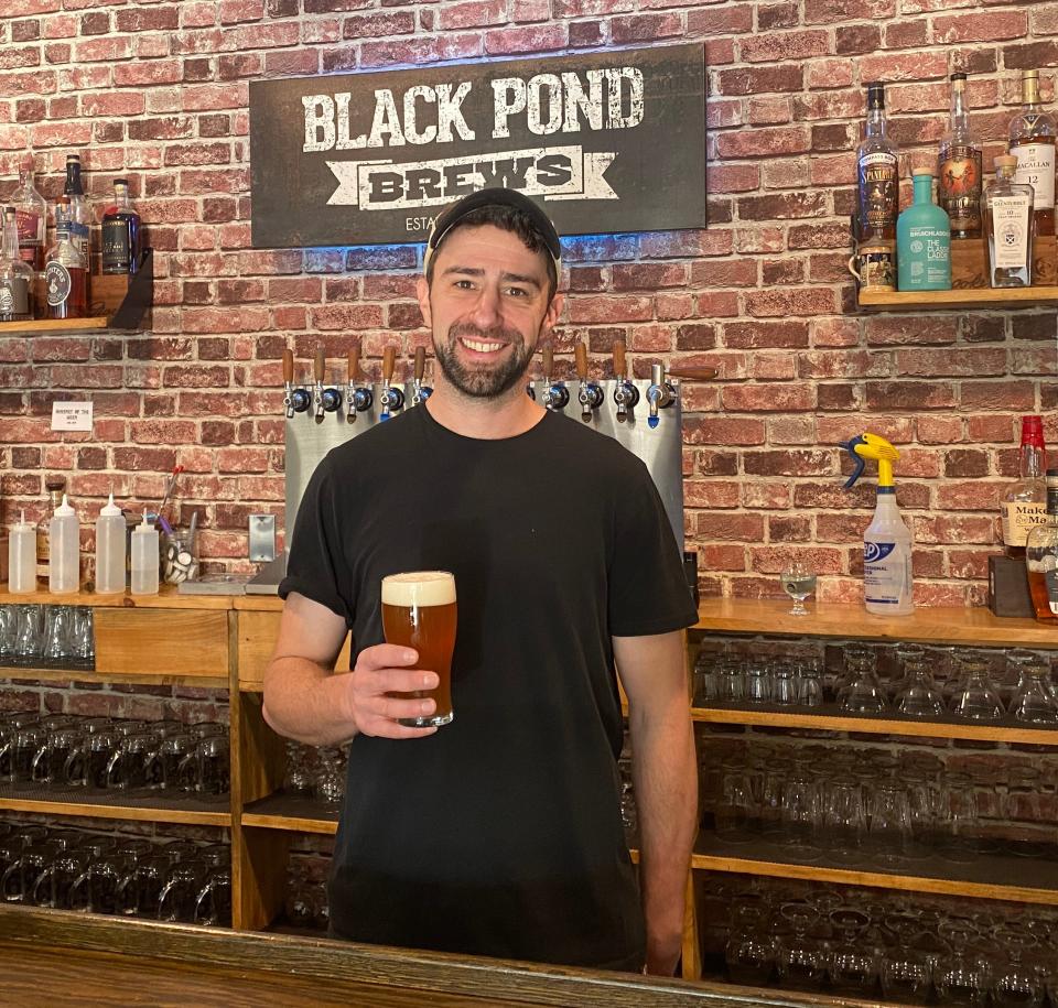 Cory Smith, co-founder of Black Pond Brews in Dayville, holds a glass of Connecticut Uncommon on draft.