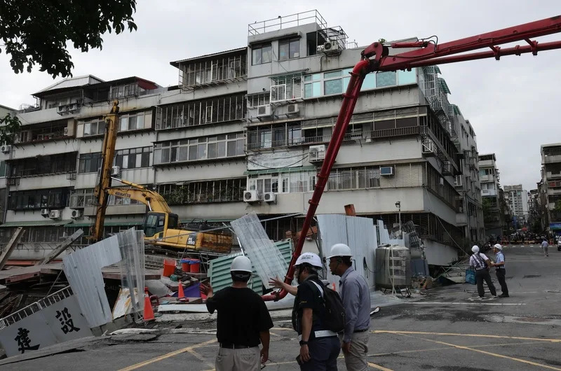 台北市中山區大直街巷弄多棟大樓7日疑因周邊建案開挖而傾斜，市府調度水車、灌漿車到場，持續以灌漿方式讓壓力維持平衡，避免房屋嚴重傾斜。圖為8日上午現場作業情形。（中央社）