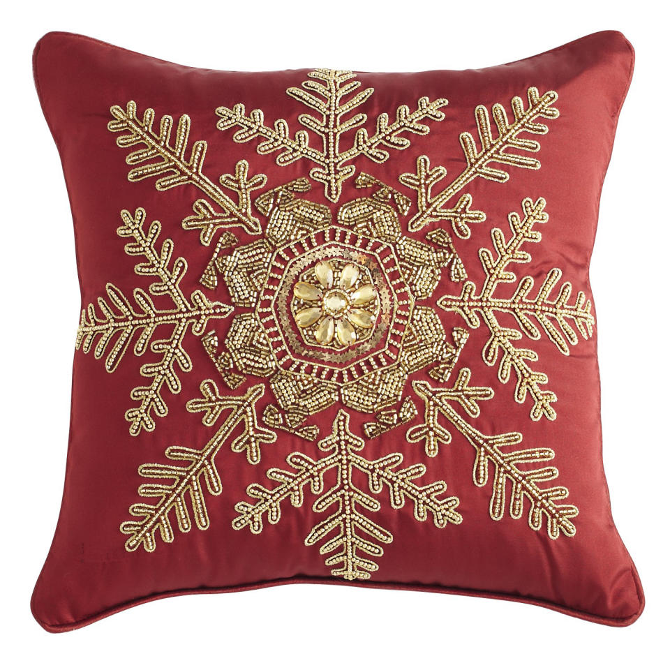 In this photo provided by Pier 1 Imports, gold beading and the deep hue of this snowflake-emblazoned pillow from Pier1.com reference two big holiday themes; metallics and crimson red. Following the general trend in home decor, holiday trim and accessories this year are a mix of eclectic and traditional colors and styles. Style watchers say we’re approaching the holidays with a more open mind, and decor has never been more expansive in terms of what works. (AP Photo/Pier 1 Imports)