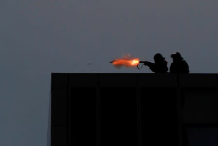 A riot police fires tear gas from balcony at government headquarters to disperse anti-extradition bill protesters during a march in Hong Kong