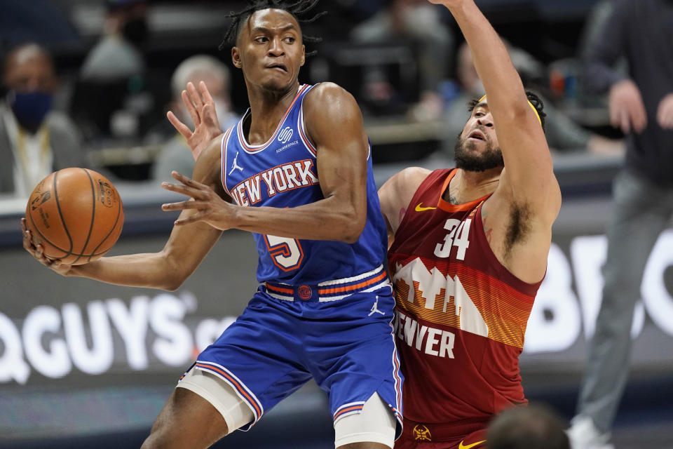 Immanuel Quickley looks to pass the ball as JaVale McGee defends.