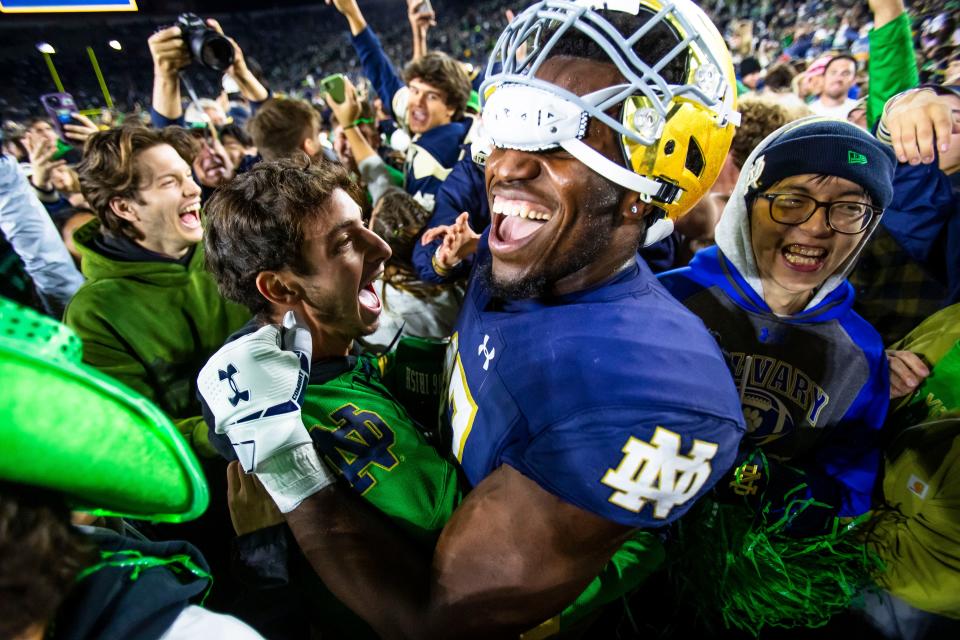 Notre Dame defensive lineman Jason Onye (47) celebrates with students after they stormed the field after an NCAA college football game against Southern California on Oct. 14 in South Bend, Indiana.