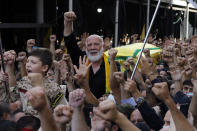 Hezbollah supporter Hassan al-Sayyed chants slogans as mourners carry the coffin of his son Mohammed, who was killed during Thursday clashes, during his funeral processions in the southern Beirut suburb of Dahiyeh, Lebanon, Friday, Oct. 15, 2021. The government called for a day of mourning following the armed clashes, in which gunmen used automatic weapons and rocket-propelled grenades on the streets of the capital, echoing the nation's darkest era of the 1975-90 civil war. (AP Photo/Bilal Hussein)