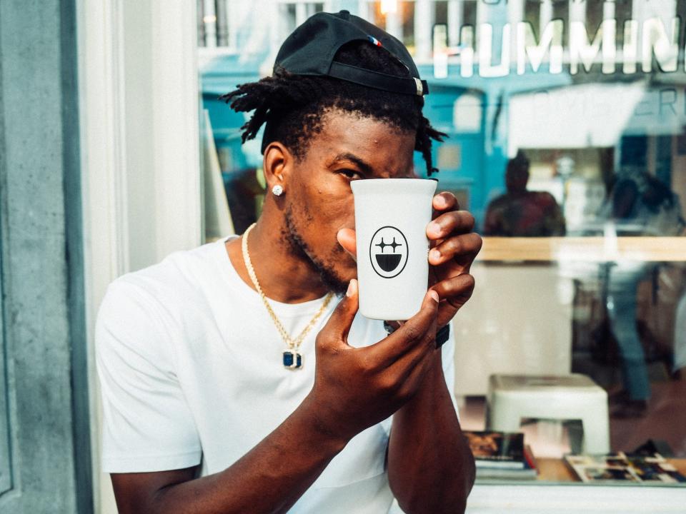 Jimmy Butler holds up a BIGFACE cup of coffee.