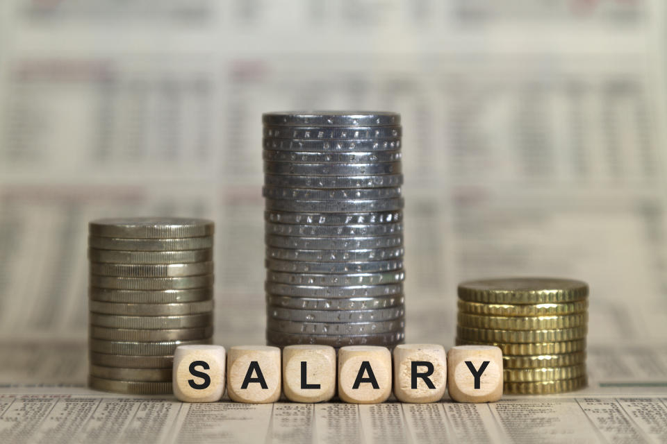 Salary winner's pedestal from coins on a business newspaper