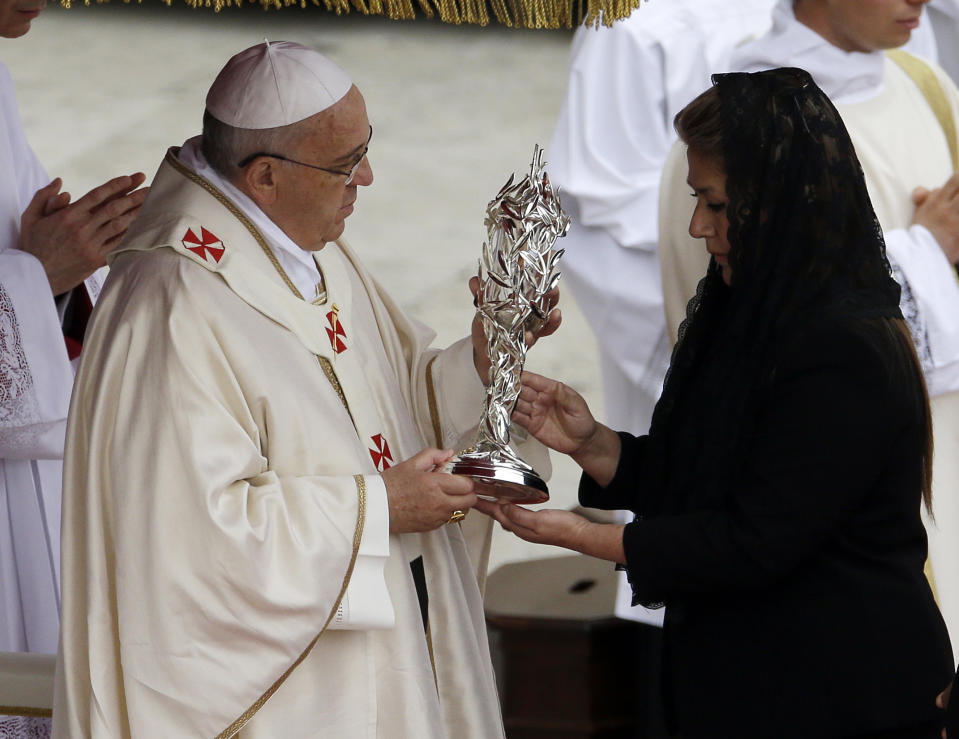 Pope Francis receives the relic of Pope John Paul II from Floribeth Mora, a Costa Rican woman whose inoperable brain aneurysm purportedly disappeared after she prayed to John Paul II, during a solemn ceremony in St. Peter's Square at the Vatican, Sunday, April 27, 2014. Pope Francis has declared his two predecessors John XXIII and John Paul II saints in an unprecedented canonization ceremony made even more historic by the presence of retired Pope Benedict XVI. (AP Photo/Gregorio Borgia)