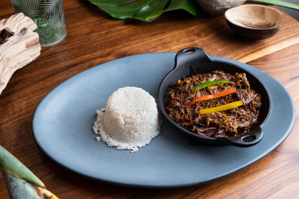 A plate of rice and shredded beef with vegetables.