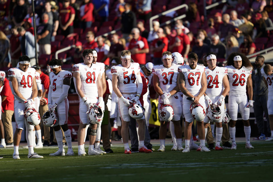 Utah players observe a moment of silence in honor of slain teammate Aaron Lowe before an NCAA college football game against Southern California on Saturday, Oct. 9, 2021, in Los Angeles. (AP Photo/Marcio Jose Sanchez)