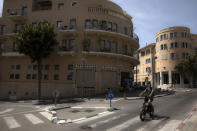 A man rides a bicycle in the Jaffa neighborhood of Tel Aviv, Israel, Wednesday, April 21, 2021. Historic Jaffa's rapid gentrification in recent years is coming at the expense of its mostly Arab lower class. With housing prices out of reach, discontent over the city’s rapid transformation into a bastion for Israel’s ultra-wealthy is reaching a boiling point. (AP Photo/Sebastian Scheiner)