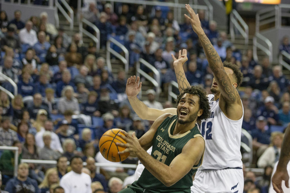 Colorado State forward Rashaan Mbemba (21) shoots over Nevada forward K.J. Hymes (42) during the first half of an NCAA college basketball game, Wednesday, Jan. 24, 2024 in Reno, Nev. (AP Photo/Tom R. Smedes)