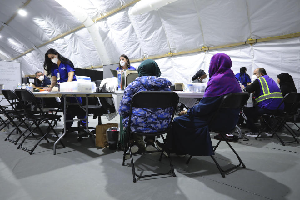 FILE - Afghan refugee women register to be seen by a doctor inside the medical tent at Liberty Village on Joint Base McGuire-Dix- Lakehurst, N.J., on Dec, 2, 2021. Military bases that housed tens of thousands of Afghan refugees after the U.S. airlifted them out of Kabul last year incurred almost $260 million in damages that in some cases rendered buildings unusable for troops until they get significant repairs to walls and plumbing, the Pentagon’s inspector general found. Tens of thousands of Afghan refugees were flown to eight military bases in the U.S. where many of them lived for months while they waited fro visa processing and resettlement. (Barbara Davidson/Pool via AP, File)