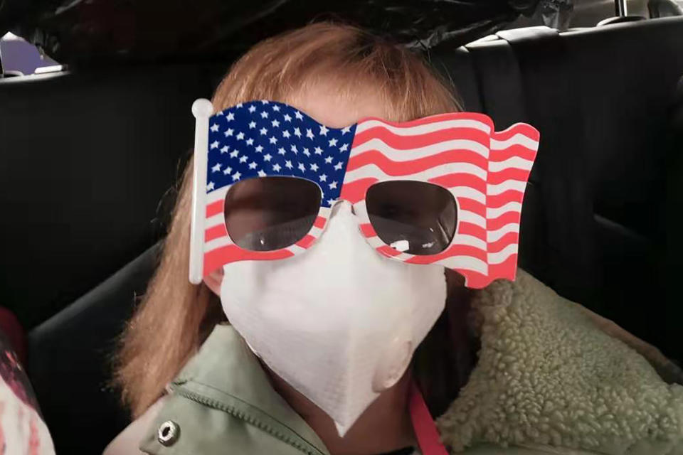 FILE - In this Tuesday, Jan. 28, 2020, file photo, Hermoine Dickey, 8, rides in a car on her way to Wuhan Tiange International Airport for a U.S. evacuation flight. Face masks are in short supply in parts of the world as people try to stop the spread of a new virus from China. Health officials recommend strap-on medical masks for people being evaluated for the new virus, their household members and caregivers. (Priscilla Dickey via AP, File)
