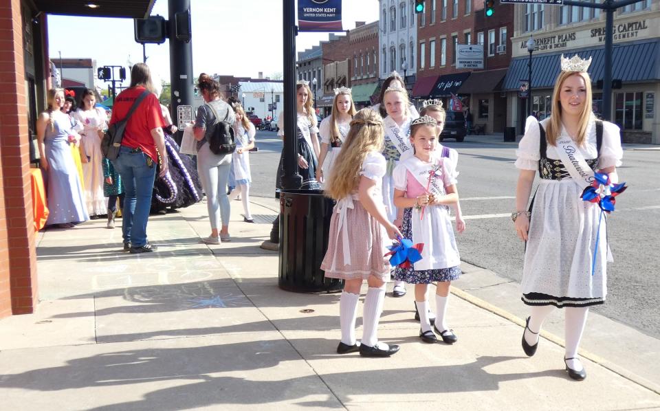 Members of the Bucyrus Bratwurst Festival court, led by 2022 Queen Hannah Feldman, stroll through downtown Bucyrus during the Bucyrus Area Chamber of Commerce’s May First Friday event.  Raven Sharrock, dressed as “The Little Mermaid” villain Ursula, greets a fan during the Bucyrus Area Chamber of Commerce’s May First Friday event.  Eric Nassau performs in front of the Great American Crossroads mural in Millennium Park during the Bucyrus Area Chamber of Commerce’s May First Friday event.  A couple strolls through downtown Bucyrus during the Bucyrus Area Chamber of Commerce’s May First Friday event.