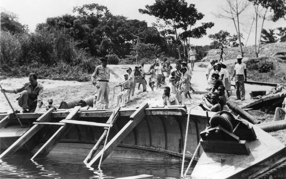 John Huston oversees the refloating of the African Queen herself, after her sinking - Alamy