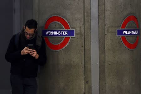 A commuter stands next to a tube sign reading 'Webminster' after Amazon rebranded Westminster tube station as a marketing stunt in central London, Britain January 12, 2017. REUTERS/Stefan Wermuth