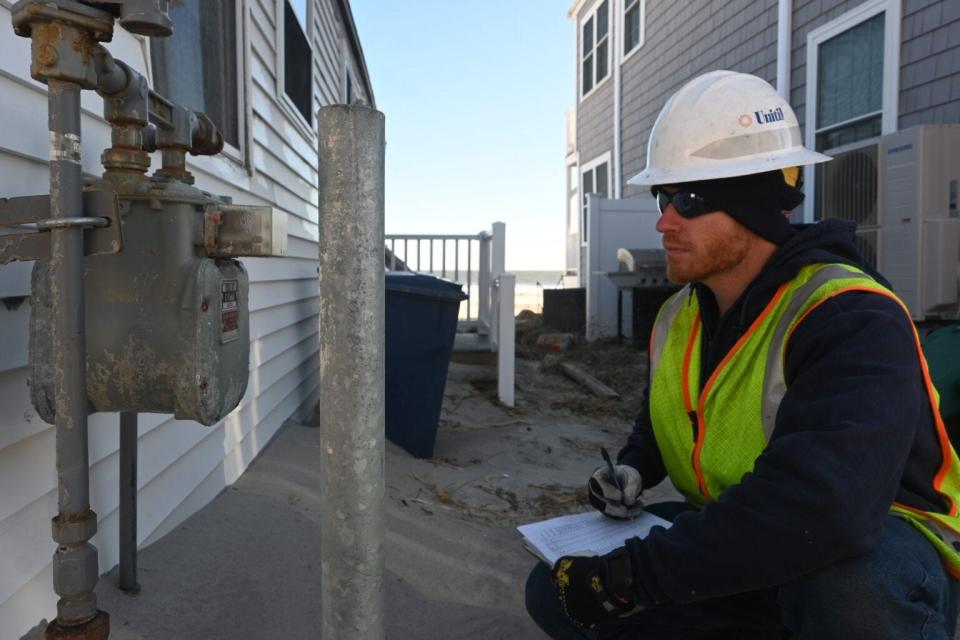 Unitil gas technician Scott Murray checks gas service meters at Hampton Beach after historic high-tide flooding on Jan. 13.