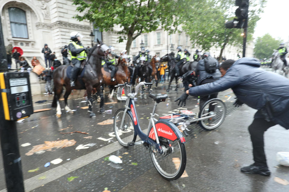 A bicycle is thrown at mounted police Police on horseback in Whitehall following a Black Lives Matter protest rally in Parliament Square, London, in memory of George Floyd who was killed on May 25 while in police custody in the US city of Minneapolis.