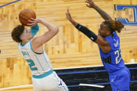 Charlotte Hornets guard LaMelo Ball (2) takes a shot over Orlando Magic guard Jordan Bone, right, during the first half of an NBA basketball game, Sunday, Jan. 24, 2021, in Orlando, Fla. (AP Photo/John Raoux)