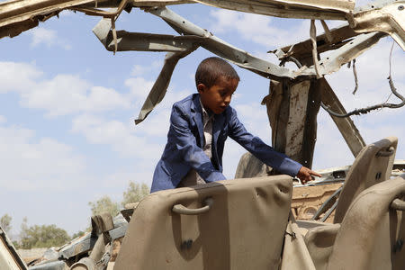 Hafidh Abdullah al-Khawlani, who survived a Saudi-led air strike stands on the wreckage of a bus destroyed by the strike in Saada, Yemen September 4, 2018. His brother was killed by the air strike. Picture taken September 4, 2018. REUTERS/Naif Rahma