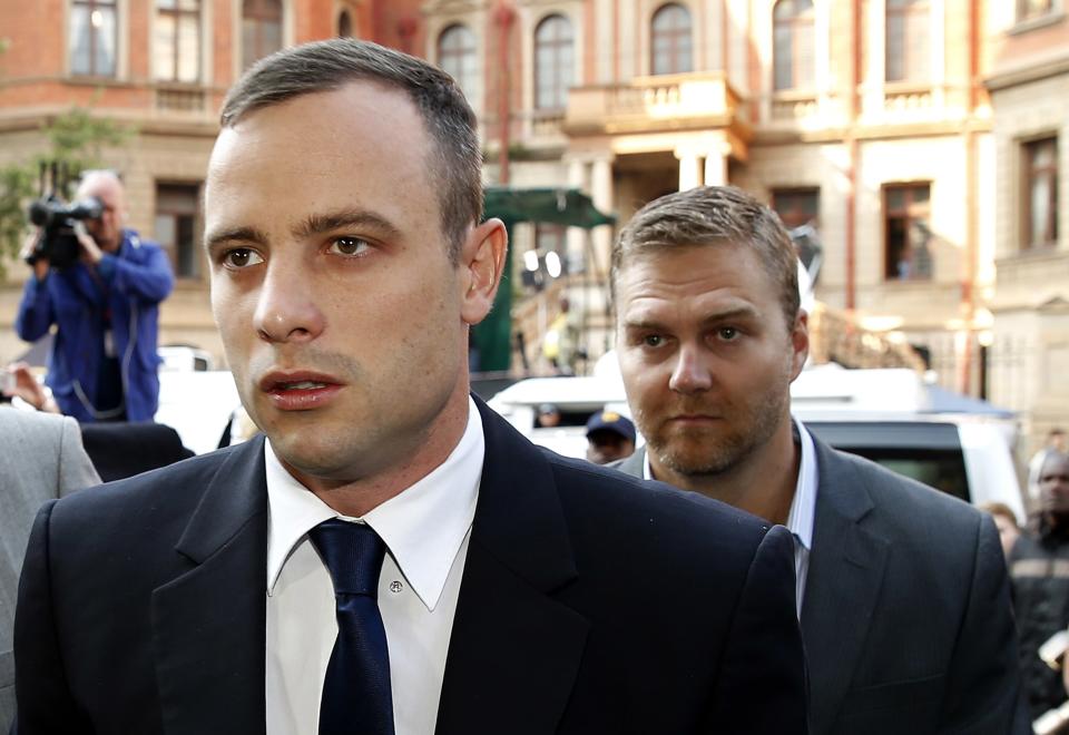 Olympic and Paralympic track star Oscar Pistorius (L) arrives ahead of his trial at North Gauteng High Court in Pretoria April 15, 2014. Pistorius is on trial for the killing of his girlfriend Reeva Steenkamp at his suburban Pretoria home on Valentine's Day last year. He said he mistook her for an intruder. REUTERS/Siphiwe Sibeko (SOUTH AFRICA - Tags: SPORT CRIME LAW ATHLETICS)