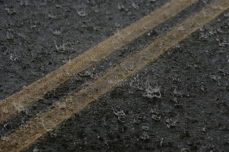 Tropical rain splashes on a runway as HH-60 Blackhawk helicopters from 101st Airborne Division's "Dustoff" unit wait for weather to clear during recovery efforts following Hurricane Maria, in Isla Grande, Puerto Rico, October 6, 2017. REUTERS/Lucas Jackson