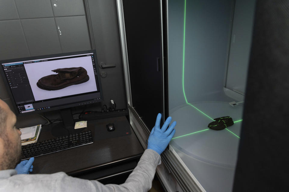 Miroslaw Maciaszczyk, a conservation specialist, scans a shoe that belonged to a child victim of the former Nazi German death camp Auschwitz-Birkenau at the conservation laboratory on the grounds of the camp in Oswiecim, Poland, Wednesday, May 10, 2023. (AP Photo/Michal Dyjuk)