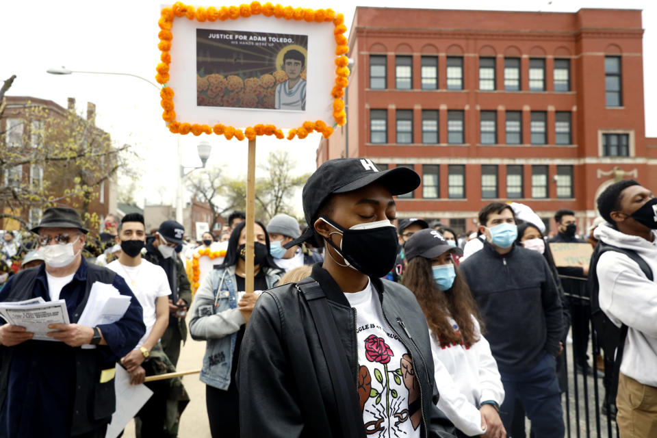 A woman closes her eyes as she participates in a moment of silence during a peace walk honoring the life of police shooting victim 13-year-old Adam Toledo, Sunday, April 18, 2021 in Chicago's Little Village neighborhood. (AP Photo/Shafkat Anowar)